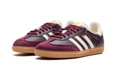 The Women’s adidas Samba OG “Maroon/Cream White” is a women’s-exclusive colorway of the classic indoor soccer shoe with a maroon-based appearance.  The upper features a maroon leather base with a tonal suede overlay on the toe.  Cream White Three Stripes branding appears on both sides, while a gold “Samba” logo can be found on the lateral side of the midfoot.  Gold adidas branding appears on the Cream White tongue.  Underfoot, a gum rubber sole rounds out the look. Maroon Sambas, Burgundy Tennis Shoes, Maroon Clothing, Adidas Shoes Samba, Maroon Adidas, White Tongue, Stripes Branding, Maroon Shoes, Burgundy Sneakers