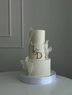 a three tiered wedding cake with white frosting and flowers on the bottom layer