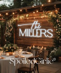 the miller's sign is lit up at night with candles and flowers around it