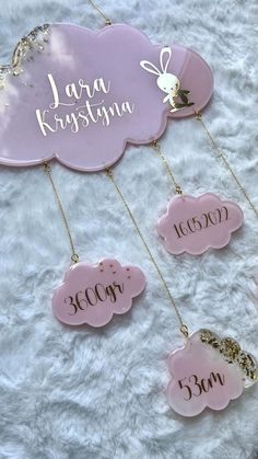 three pink clouds with gold chains hanging from them on a white furnishing area