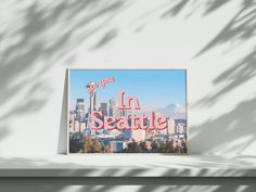 a sign that reads in seattle on the side of a building with mountains in the background