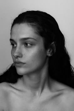 a black and white photo of a woman with freckles on her chest looking at the camera