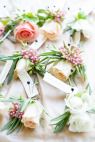 flowers are arranged in the shape of letters on a white cloth covered table with pink and green leaves