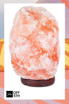 an orange rock sitting on top of a wooden stand