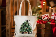 a white bag with a christmas tree on it sitting next to presents in a basket