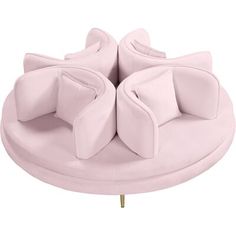 a pink couch with two bows on it's back and legs, sitting on top of a round table