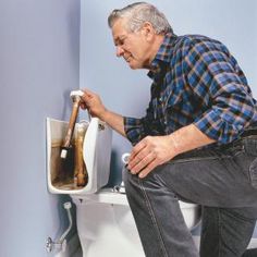 an older man is cleaning the toilet with a brush