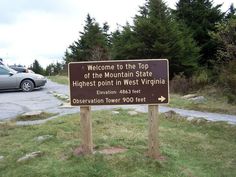 a sign that is in the grass near a road