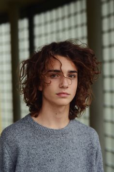 a young man with curly hair and glasses