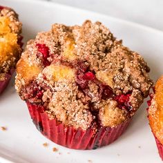 three muffins with crumbled toppings on a white plate