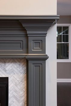 a fireplace with gray paint and white marble