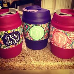 three personalized coffee cups sitting on top of a counter