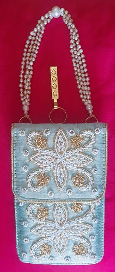 a blue purse with pearls on it