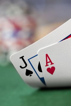 two playing cards sitting on top of each other with the letters a and j in front of them