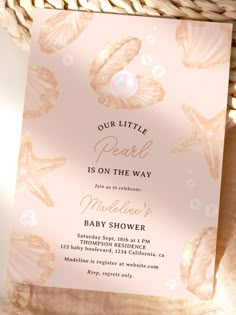 a pink and gold baby shower with seashells on it