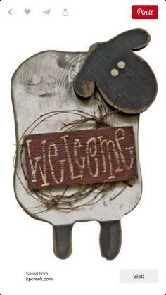 a wooden sheep with the word welcome on it's back and an image of a cow