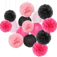 pink and black tissue pom poms are hanging from the ceiling in front of a white background