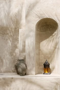 two vases sitting next to each other on a ledge in front of a wall