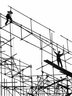 two men are working on scaffolding in the air while one man is climbing up