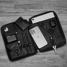 an iphone and other items are laid out in a case on a wooden table top