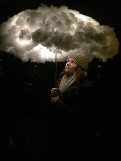 a woman holding an umbrella in front of a cloud