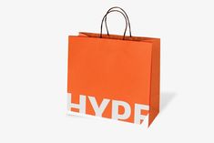 an orange shopping bag with the word hype printed on it, against a white background