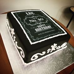 a black and white birthday cake sitting on top of a table