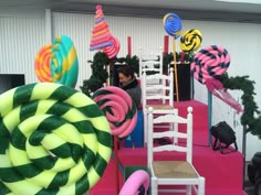 there are many colorful balloons and chairs on the pink carpeted area for children to play in