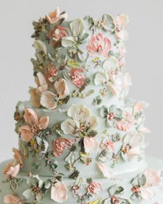 a wedding cake decorated with flowers and leaves