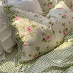 a bed with white pillows and green checkered bedspread on top of it