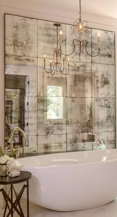 a bathroom with a large bathtub and chandelier hanging from the ceiling above it