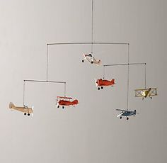 an airplane mobile is suspended in the air with other toy airplanes hanging from it's sides