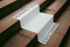 two white signs sitting on the side of some steps with words written on them in black and white