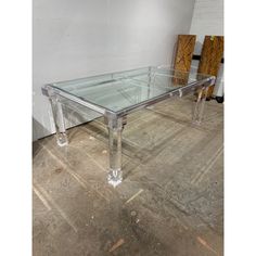 a glass and chrome coffee table in the shape of a rectangle with two legs