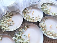 several white plates with flowers on them sitting on a table