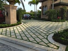 a car is parked in front of a house with palm trees on the side walk