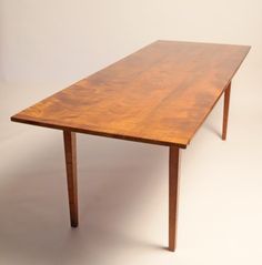 a wooden table sitting on top of a white floor