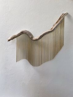 a wooden comb hanging from the side of a wall