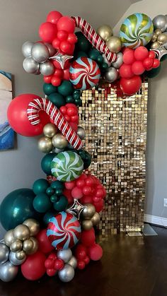 the balloon arch is decorated with red, green and silver balloons