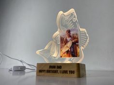 a glass trophy with an image of a man holding a fish on it's side