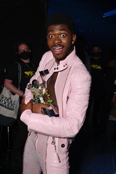 a man dressed in pink is posing for the camera