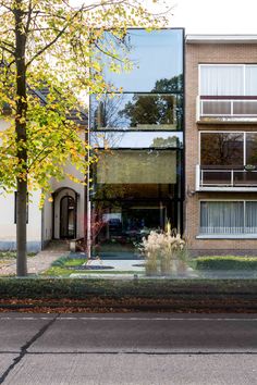 an apartment building with large glass windows on the front and side of it's facade