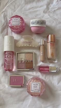 the contents of an assortment of beauty products laid out on a white sheeted surface