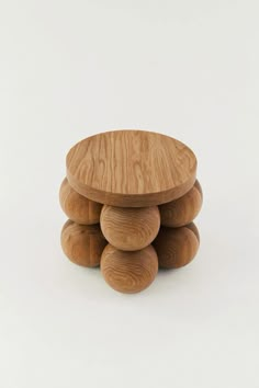 three wooden stools stacked on top of each other in front of a white background