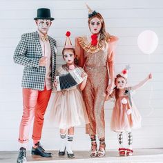 three adults and two children dressed up as clowns