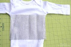 a baby's white shirt is being sewn