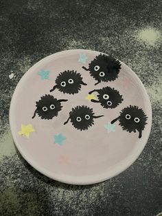 a white plate with black sheep painted on it's face and stars around the eyes