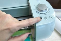 a person pressing buttons on an appliance with their thumb and index finger pointing at the button