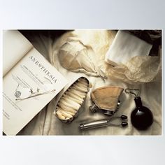 an open book and some other items on a bed with white sheets, including hairbrushes