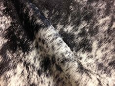 black and white cow print fabric with very soft fur on the bottom half of it